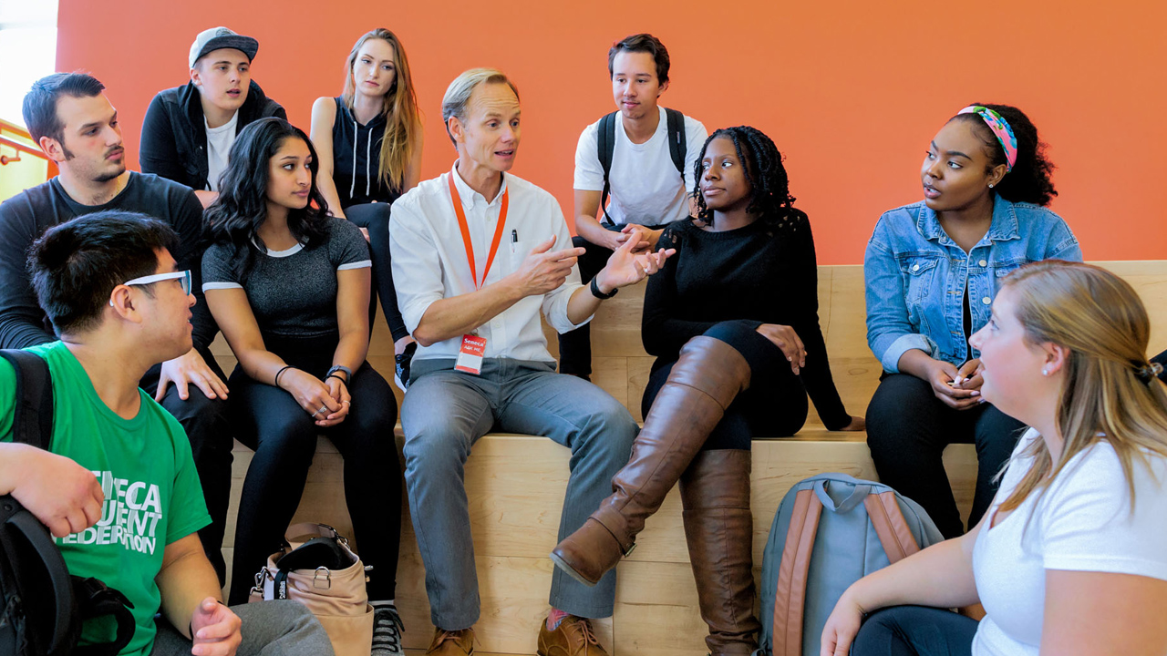 Professor speaking to students on stairs