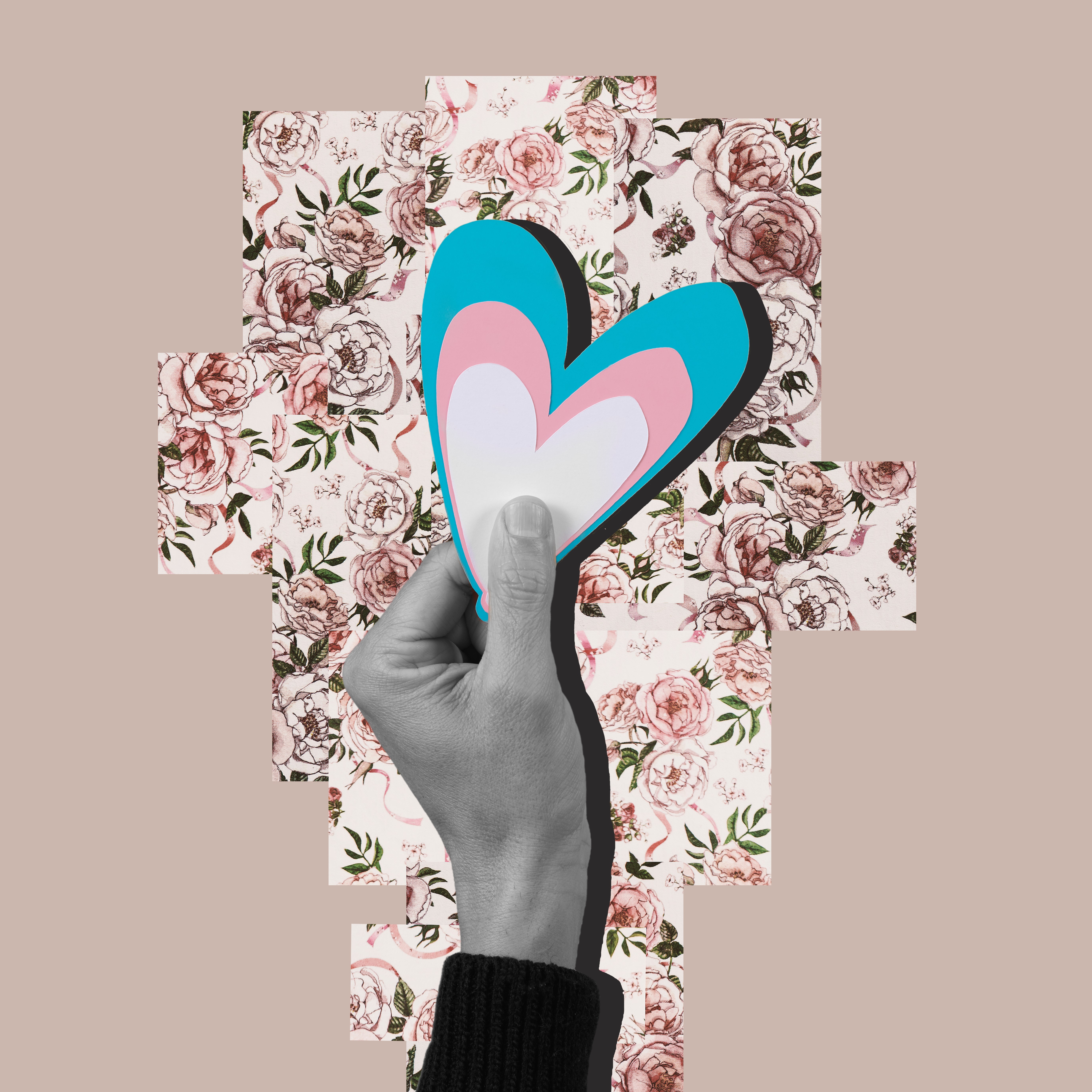 Black and white hand holding a collage of a heart with the trans flag colours (blue, white, and pink). Hand is above a floral pattern. Background is beige.