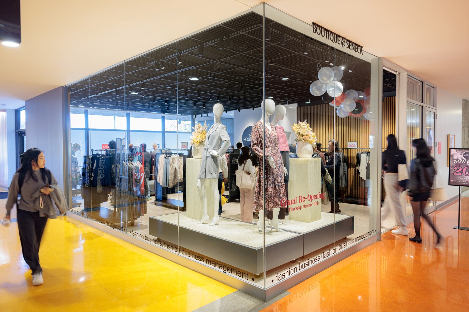 Two people are shown walking into The Boutique, Seneca's retail clothing store on Newnham Campus.