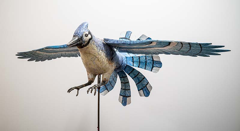 Ralph Boutilier is arguably among the very best of Canadian folk artists. His experience with painting, carpentry and mechanics is evident in his most ambitious and best-known creations, whirligigs of flying birds. In 1968 he turned to making kinetic art, “something beautiful to go with the wind”. Over the years this has yielded a flock of wind-driven birds: two Blue Jays (one of which is in the collection of the Art Gallery of Nova Scotia), kingfisher, two eagles (one of which is in the Canadian Museum of History) and a seagull.  Seneca&#39;s &quot;Blue Jay&quot; is physically located at the entrance to the Newnham Campus Library. 